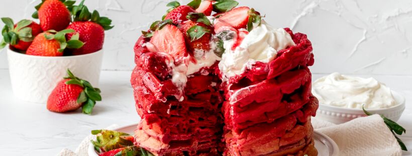 red ombre waffles topped with whipped cream and strawberries