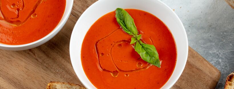 creamy roasted tomato and coconut soup on a wooden board